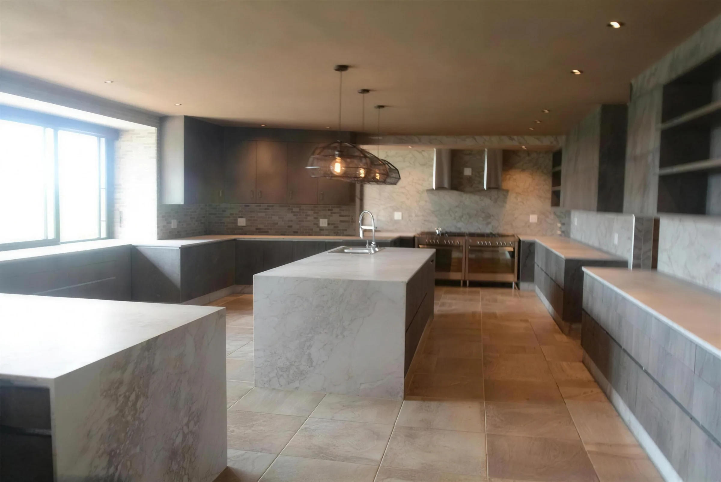 Kitchen Units 01: A marble-topped island kitchen with copper pendants, built into an open-plan living space.