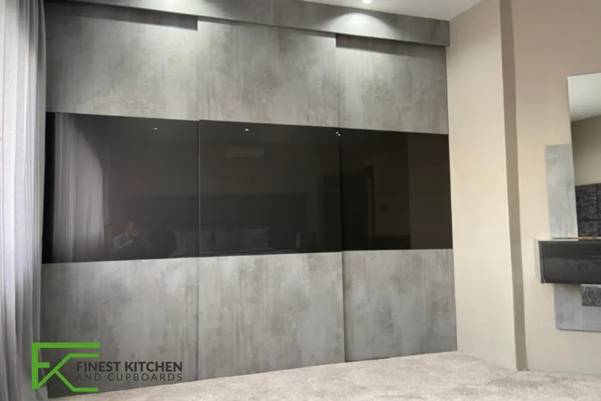 A dark FKC feature wall unit with a recessed television niche, built beside a staircase.