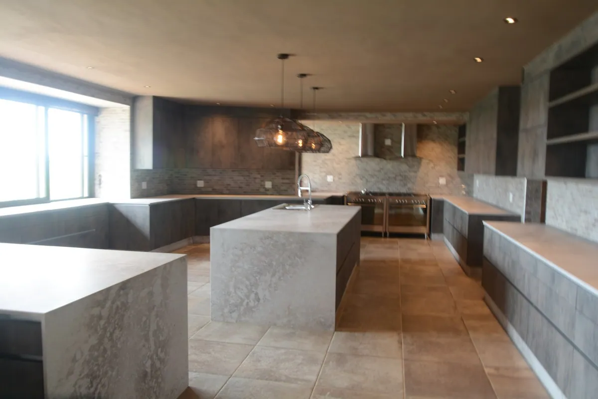 Kitchen Units 01: A marble-topped island kitchen with copper pendants, built into an open-plan living space.